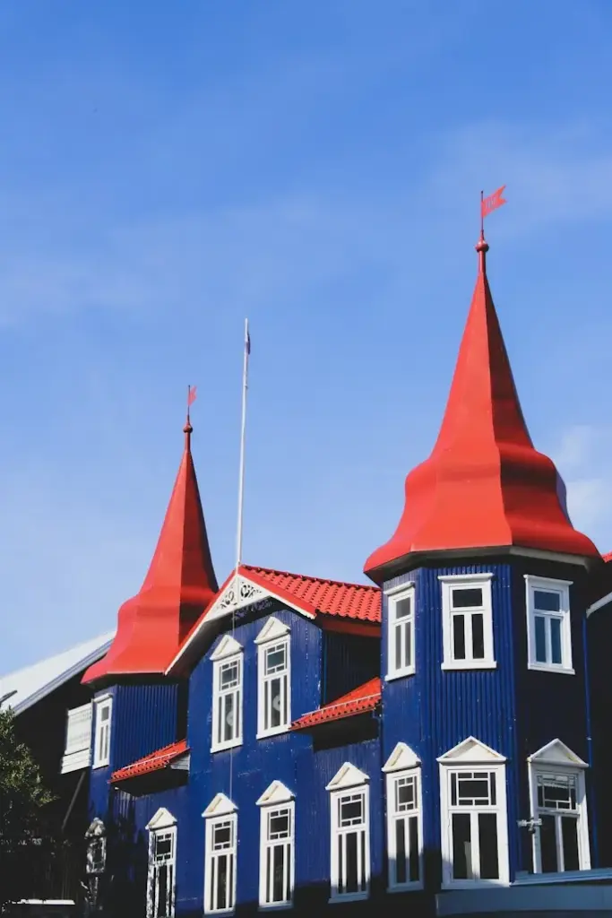 İzlanda'nın enerjik başkenti Reykjavik'in ikonik renkli evlerinden biri olan, sivri kırmızı çatılı ve beyaz pencereli bu canlı mavi bina, şehrin kendine özgü mimarisini yansıtan büyüleyici bir görüntü sunuyor.