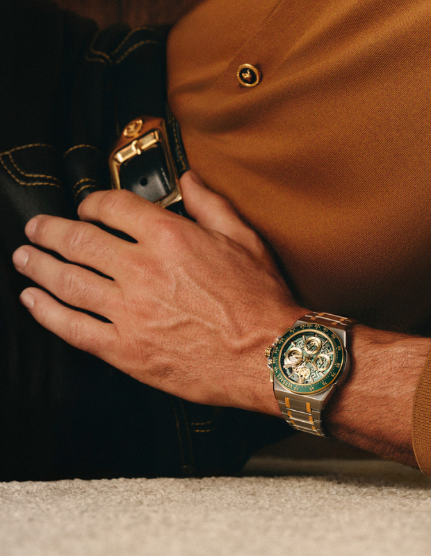 Versace erkek kol saati – altın detaylı, yeşil kadranlı Greca motifli lüks saat modeli, erkek bileğinde stilize çekim.