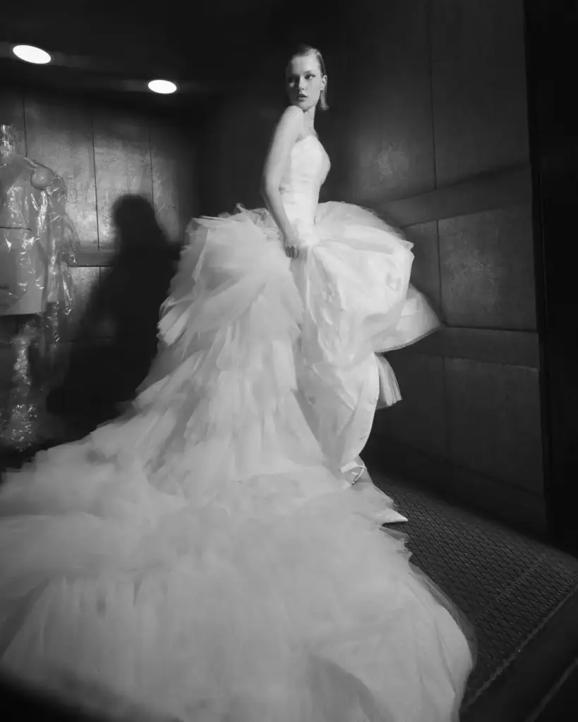 Siyah beyaz çekimde hacimli tül eteği ve straplez üstüyle dramatik bir gelinlik giyen model – haute couture bridal görünüm.