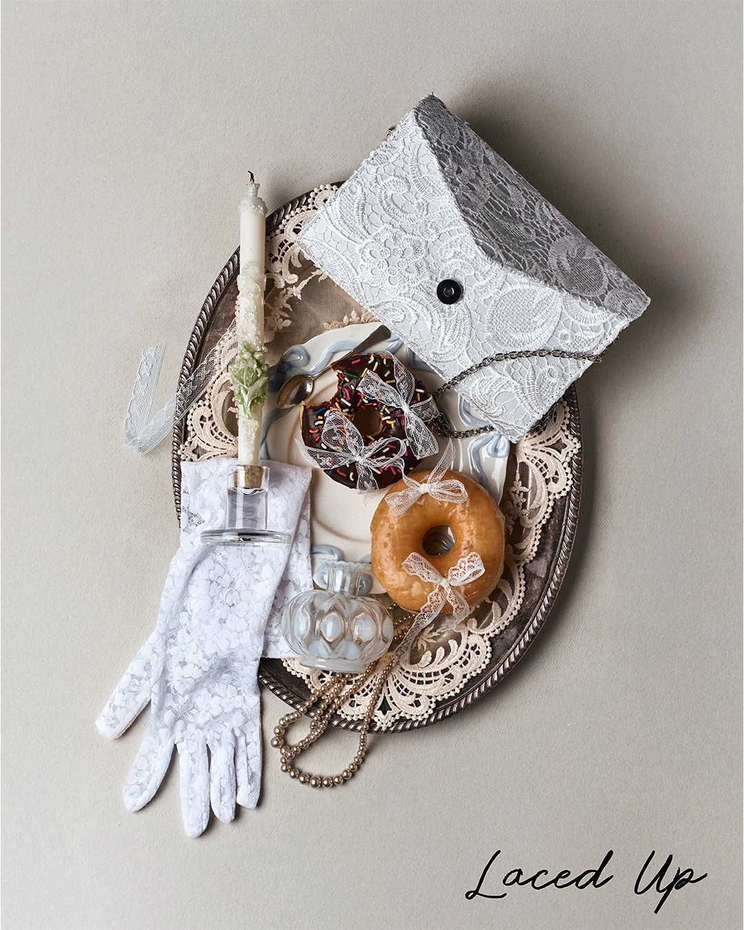 Dantel detaylı vintage stil flat lay kompozisyon; dantel eldiven, dantel kaplama clutch çanta, inci kolye, mum ve fiyonk detaylı donut ile romantik ve nostaljik estetik, 2026 Pinterest dantel trendi.