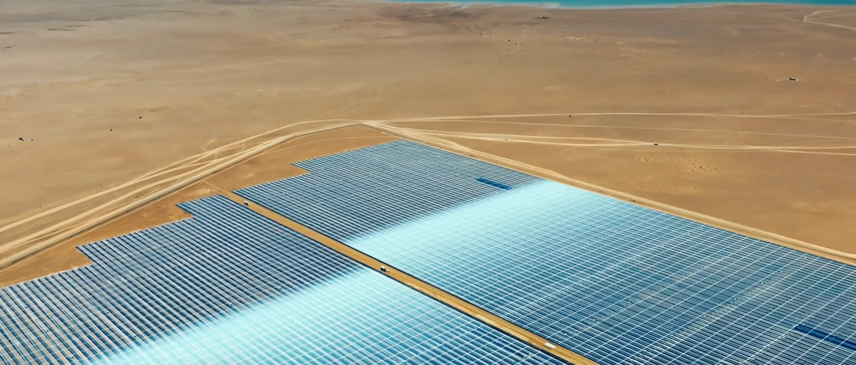 Çöl arazisine kurulu geniş güneş enerjisi santrali, yenilenebilir enerji ve sürdürülebilir teknoloji yatırımları.