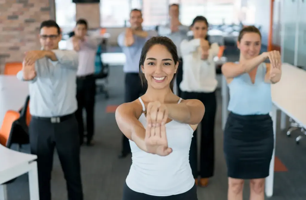 İşyerinde wellbeing kültürü; ofis ortamında çalışanların birlikte esneme hareketi yaptığı grup aktivitesi.