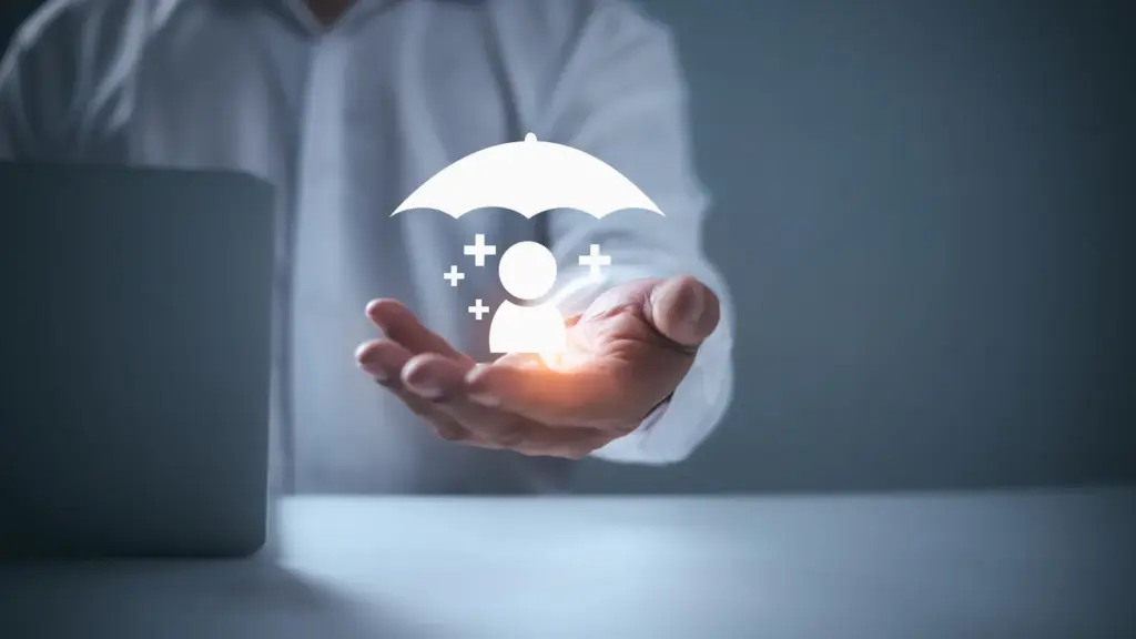 Kurumsal wellbeing ve çalışan güvenliğini simgeleyen, avuç içinde tutulan holografik sigorta ve koruma ikonu.
