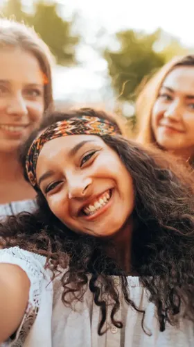 Z kuşağının sosyal wellbeing yaklaşımını yansıtan açık havada gülümseyen genç grup portresi.