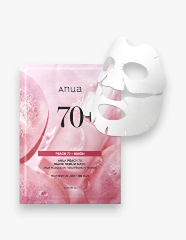 Beyaz arka planda, pembe şeftali ve damlacık desenleriyle süslenmiş Anua Peach 70 Niacin Serum Mask paketinin yanında, cilde uygulanmaya hazır, katlanmış beyaz bir kağıt maske duruyor ve ürünün niasin ile şeftali içeriğini vurguluyor.