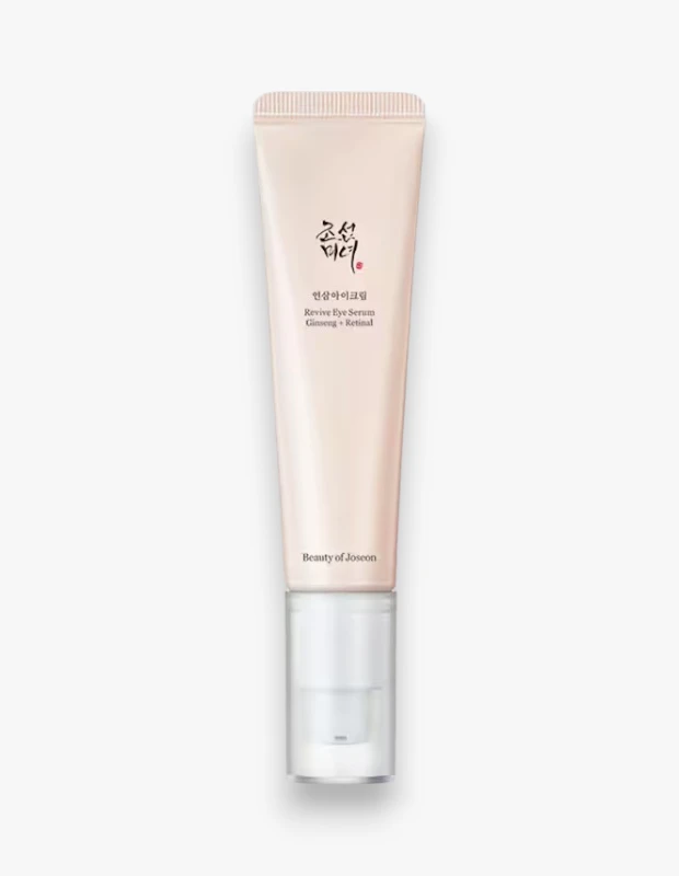 Açık bej tonlarında, dik konumlandırılmış bir Beauty of Joseon Revive Göz Serumu tüpü, sade beyaz bir zeminde duruyor; üzerinde belirgin bir şekilde Ginseng ve Retinal içerikleriyle zenginleştirildiği yazılı olan bu ürün, cildin canlanmasına yardımcı olmayı hedefleyen bir bakım öğesi olarak öne çıkıyor.