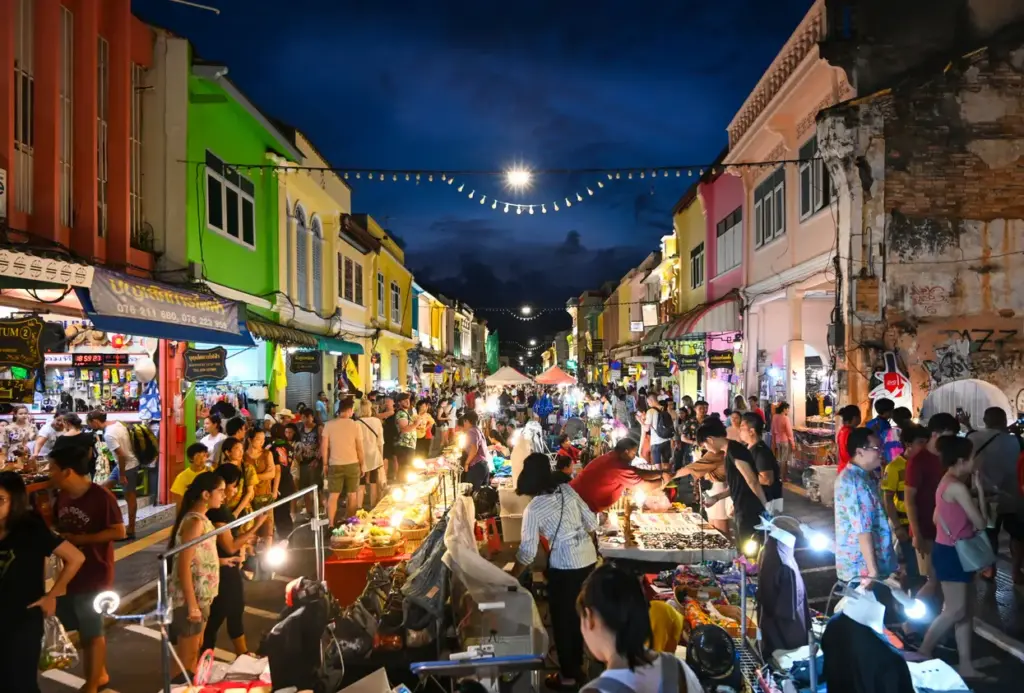 Phuket Old Town'da Thalang Caddesi'nin trafiğe kapatılarak Lard Yai adlı Pazar Yürüyüş Sokağı'na dönüştüğü, rengarenk Sino-Portekiz mimarisine sahip tarihi binalar arasında, ışıklarla aydınlatılmış tezgahları gezen kalabalıklar ve canlı atmosfer, adanın mistik tapınaklardan turkuaz kıyılara uzanan gezilecek yerlerinden birini gözler önüne seriyor.