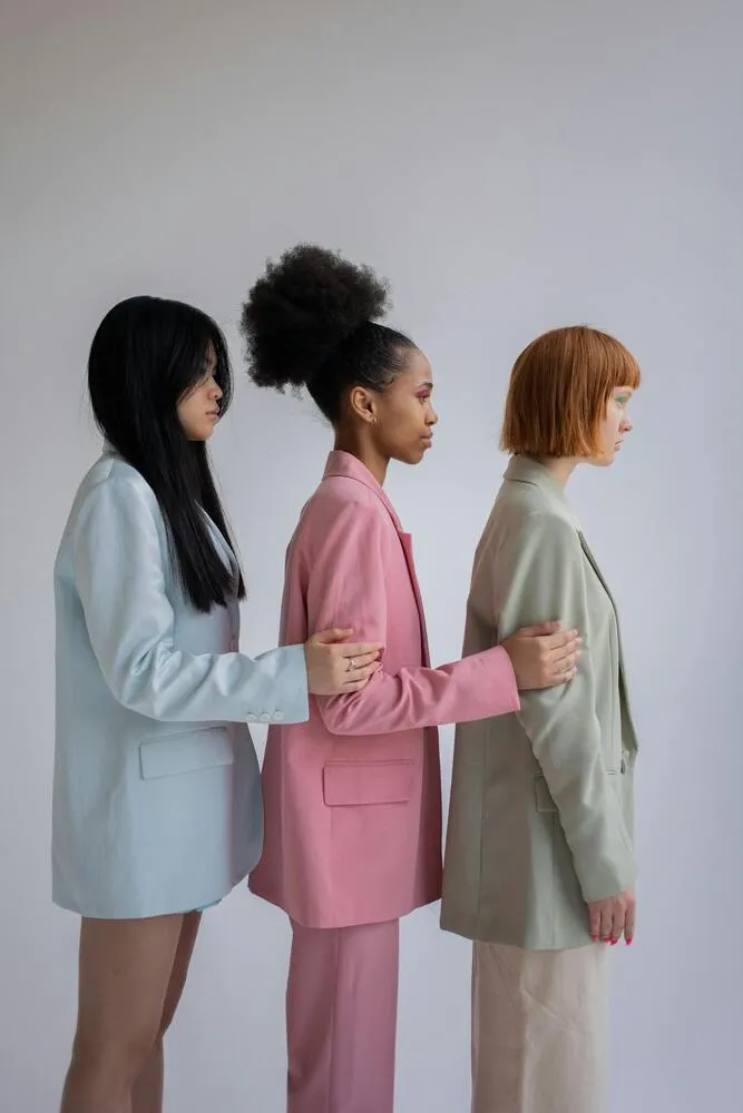Pastel tonlarda takım elbise giyen üç modelin yan yana durduğu moda çekimi; minimalizm ve modern siluetleri öne çıkaran 2026 trend estetiği.