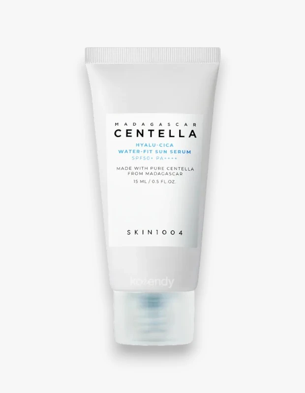 Beyaz bir arka plan üzerinde dikey duran, üzerinde siyah MADAGASCAR CENTELLA yazısı ve Hyalu-Cica Water-Fit Sun Serum SPF50+ PA++++ detayları olan 15 ml hacimli beyaz SKIN1004 güneş serumu tüpü.