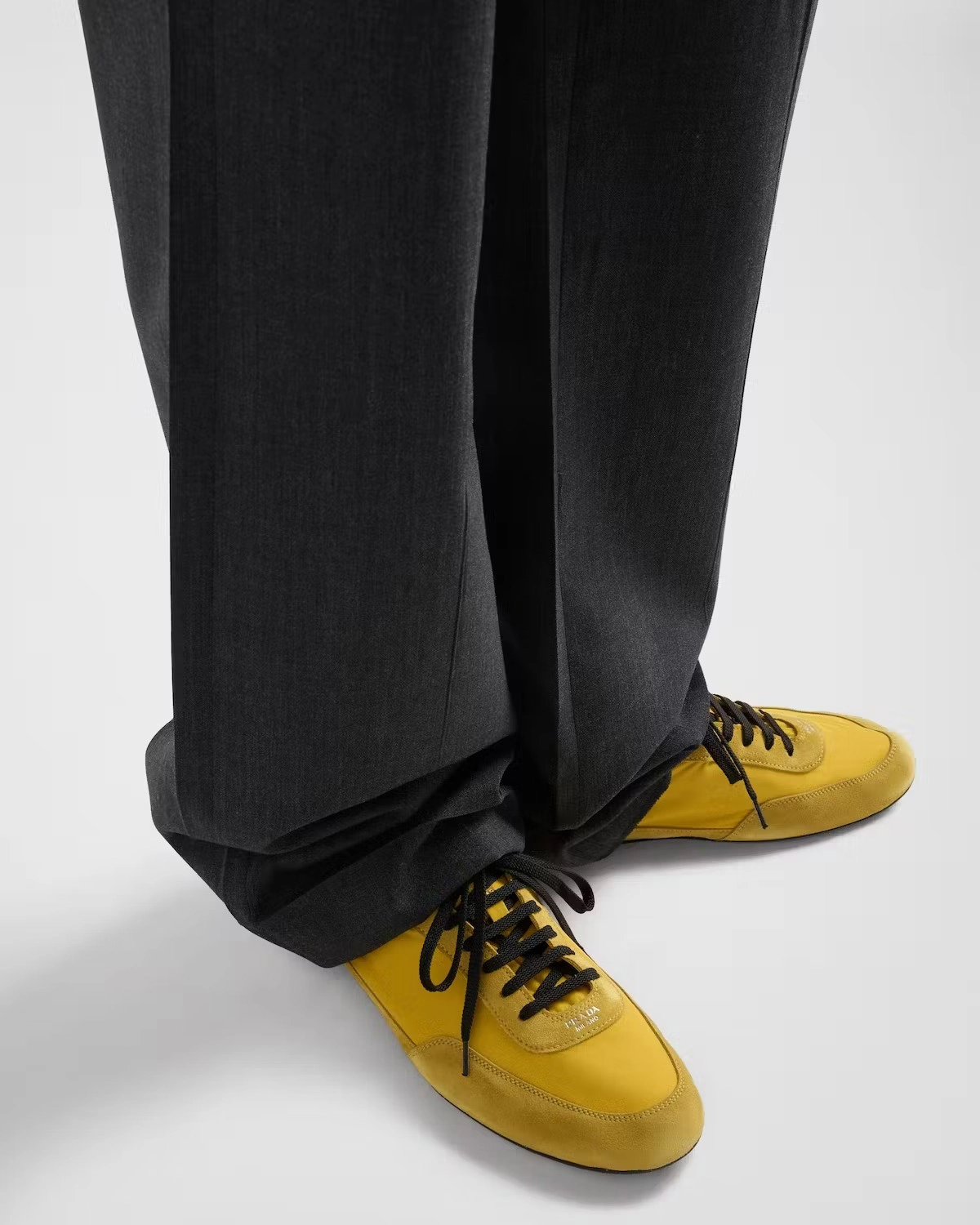 Sarı blucher sneaker modeli, koyu renk düz kesim kumaş pantolonla kombinlenerek kış sezonu için modern ve minimal bir sneaker stili sunuyor.