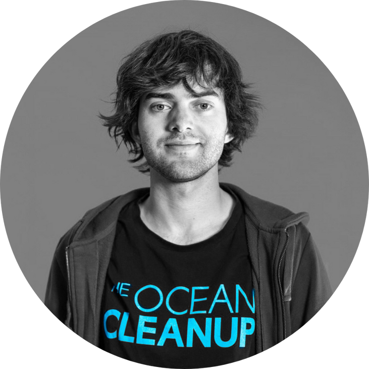 The Ocean Cleanup’ tişörtü giyen genç bir erkeğin stüdyo ortamında çekilmiş siyah-beyaz portresi; okyanus temizliği ve çevre teknolojileriyle ilişkilendirilen aktivist/proje temsilcisi fotoğrafı.