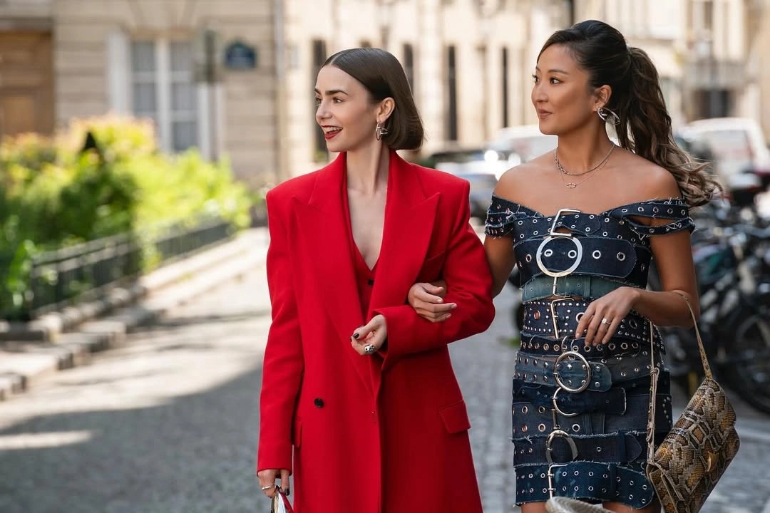 Paris sokaklarında kırmızı blazer ve siyah elbise kombiniyle Emily in Paris dizisinden şehir stili sahnesi.