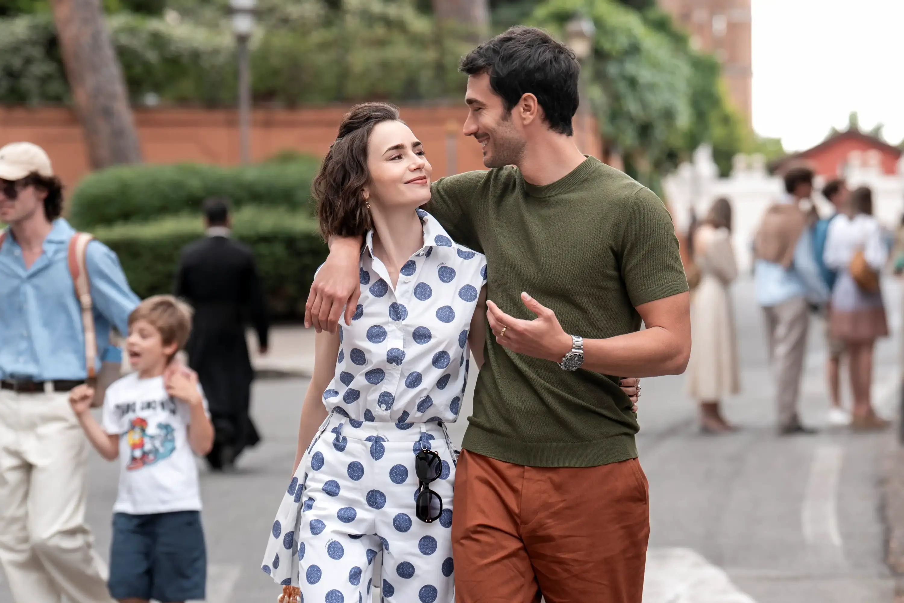 Emily in Paris dizisinde şehir sokaklarında puantiyeli tulum ve casual kombinle romantik yürüyüş sahnesi.
