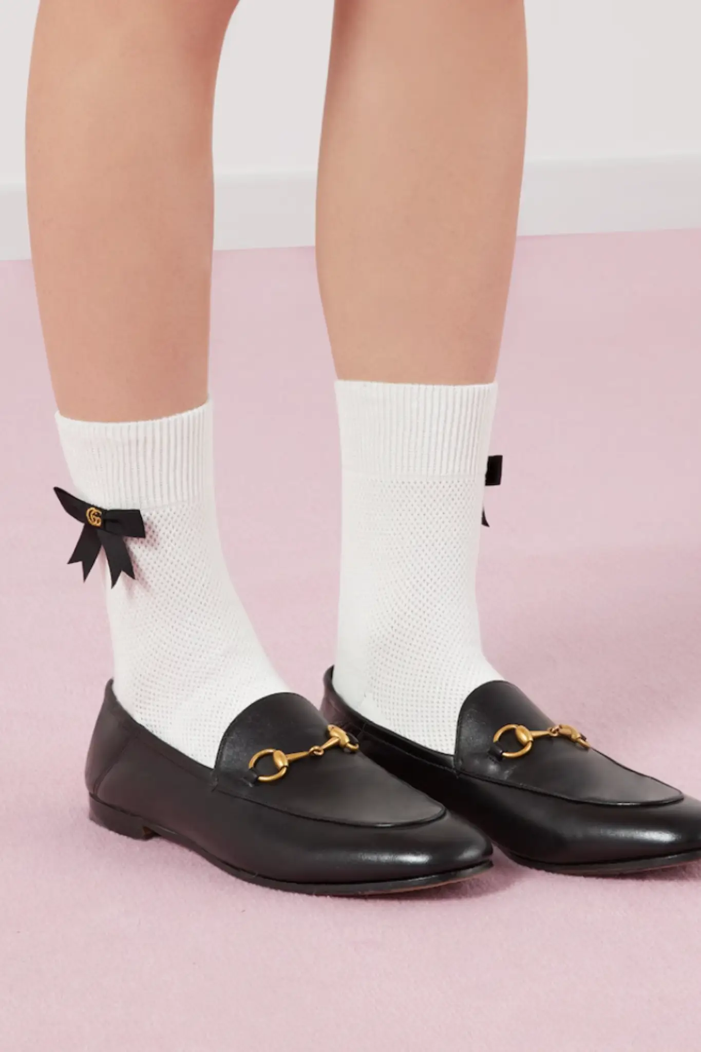 Gucci Horsebit siyah loafer ayakkabı, altın at nalı tokası ve beyaz çorapla tamamlanan ikonik preppy stil görünümü