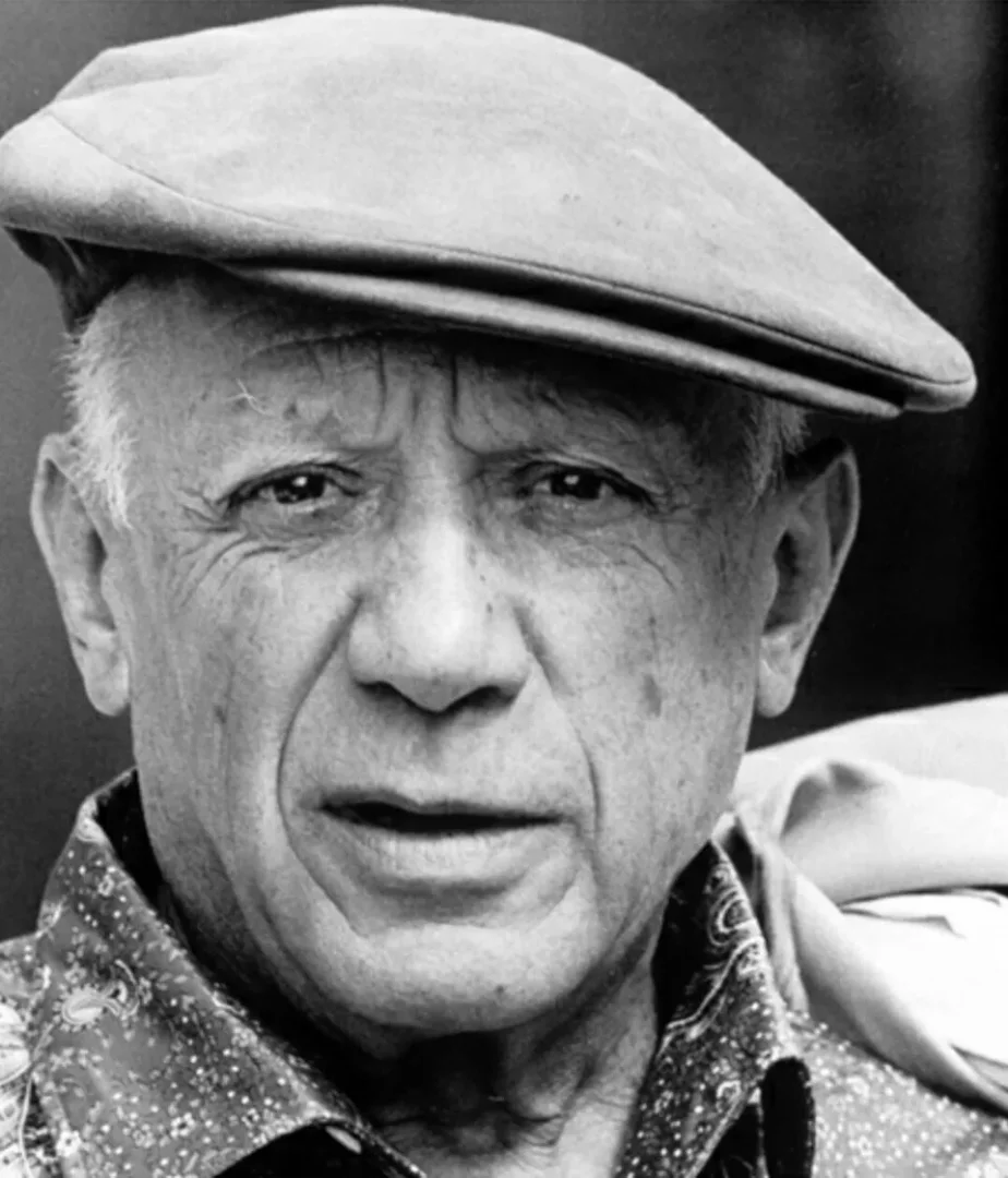 Siyah beyaz portrede, düşünceli ve derin bir ifadeyle doğrudan kameraya bakan, başında kasket ve desenli gömleği olan yaşlı Pablo Picasso'nun yüzü yakın çekim gösteriliyor, bu görüntü onun sanatındaki derinliği ve Kubizm akımına yaptığı büyük katkıyı yansıtıyor.