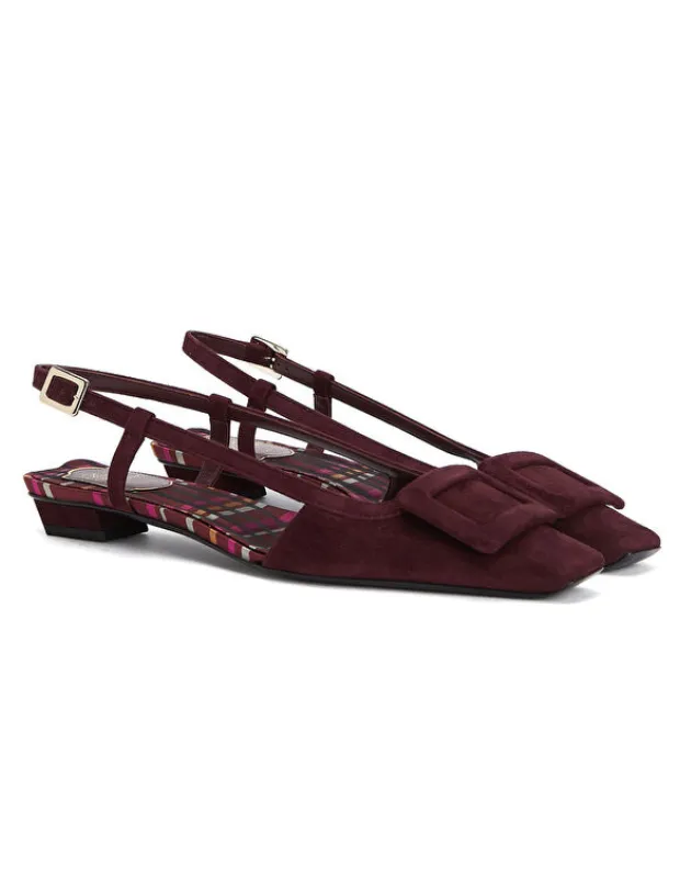 Bordo süet dokulu, kare burunlu, geniş tokasıyla dikkat çeken, alçak blok topuklu bir çift Roger Vivier slingback ayakkabı, iç tabanındaki renkli ekose deseniyle, tüm zamanların ikonik ayakkabı tasarımları arasındaki yerini zamansız duruşuyla vurguluyor.