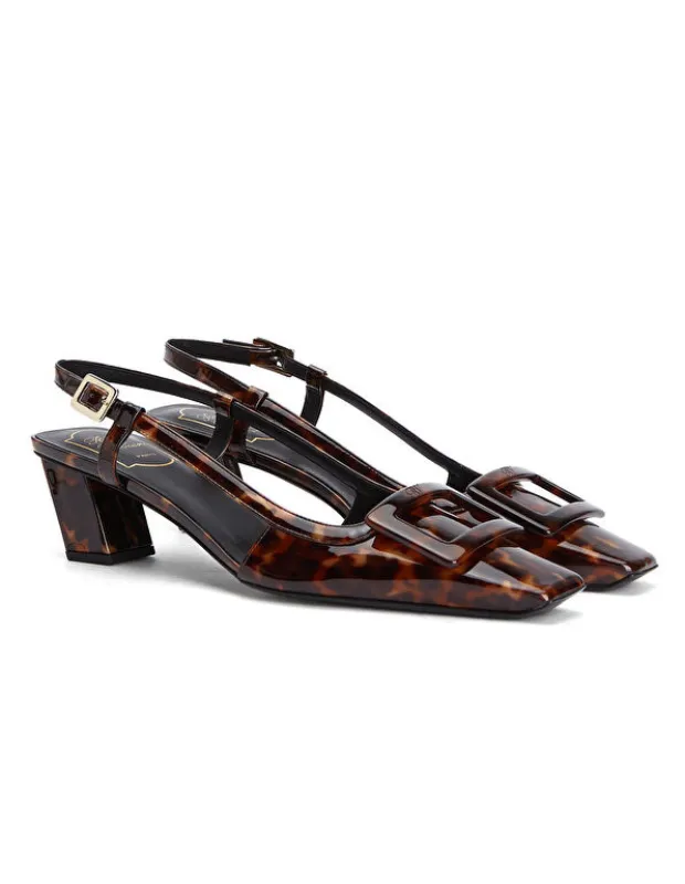 Roger Vivier'nin bağa desenli, kare burunlu, kalın topuklu ve kendine özgü ikonik Vivier tokasıyla dikkat çeken bu slingback ayakkabısı, 1960'ların mod stilinden ilham alarak tüm zamanların zamansız tasarımları arasında yerini alıyor.