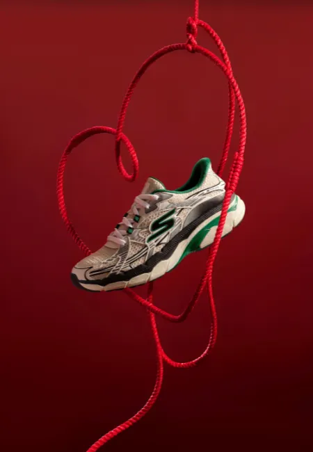 Kırmızı arka planda ip detaylarıyla asılı sneaker modeli.