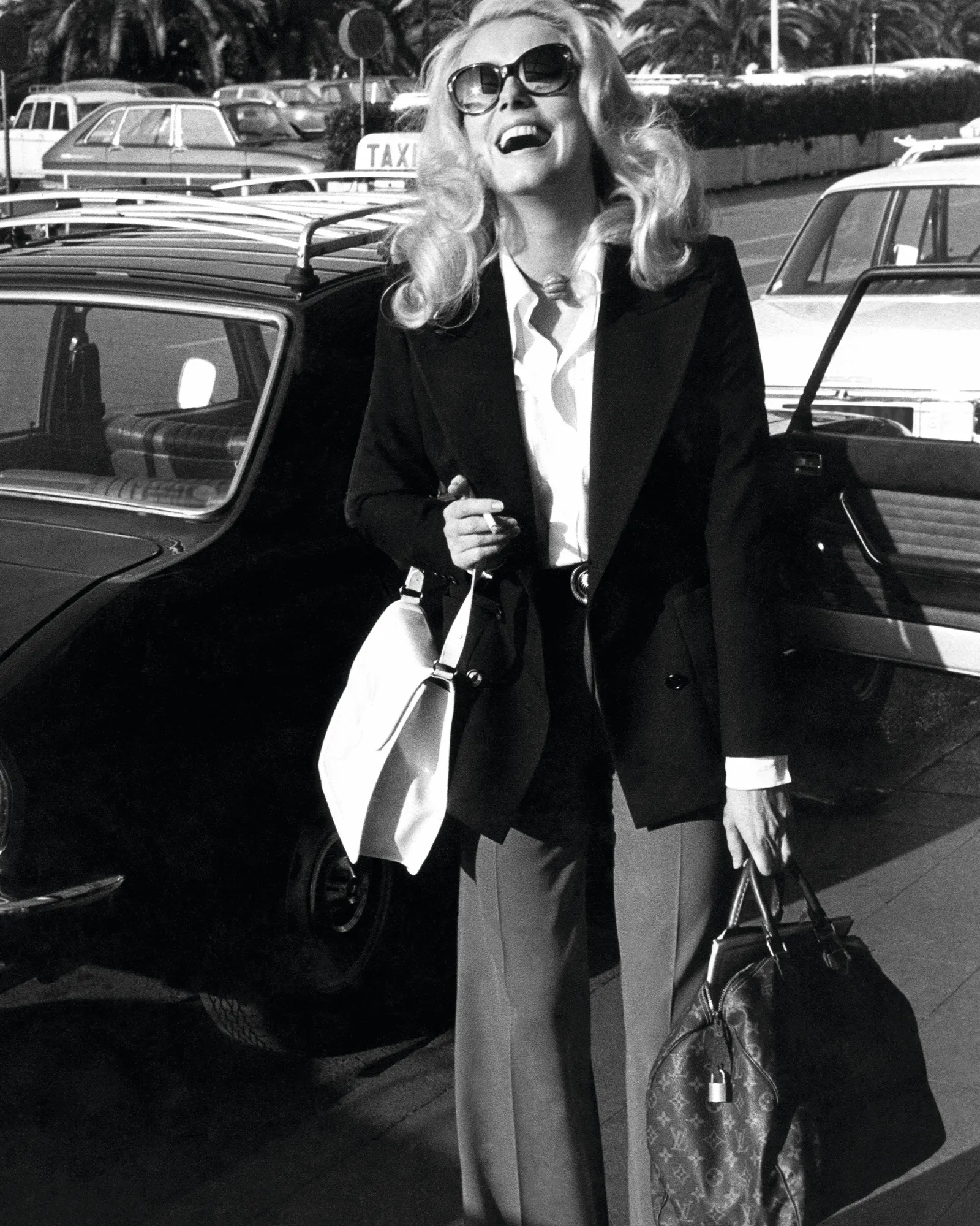Siyah beyaz karede, ikonik sarı saçları ve büyük güneş gözlükleriyle neşeyle kahkahalar atan Catherine Deneuve, TAXI yazılı bir aracın önünde, elinde markanın zanaat ve seyahat mirasından gelen ünlü Louis Vuitton Monogram desenli seyahat çantasını taşıyarak deseni ve onun 130 yıllık hikâyesini zamansız bir anla buluşturuyor.