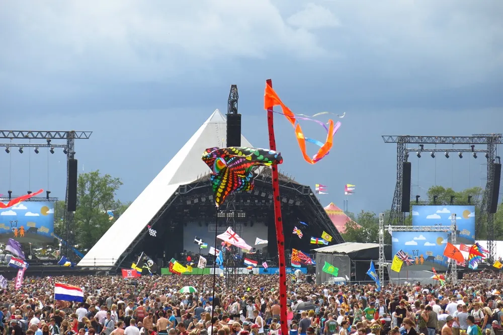 İngiltere’de Glastonbury Festivali sırasında Pyramid Stage önünde yağmurlu havaya rağmen toplanan kalabalık