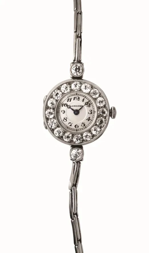 1916 tarihli antika Longines kadın kol saati. Platin kasası, beyaz kadranını çevreleyen parlak pırlantalar ve zarif metal bileziği ile 20. yüzyıl başı lüks saatçiliğinin bir örneğini sergiliyor.
