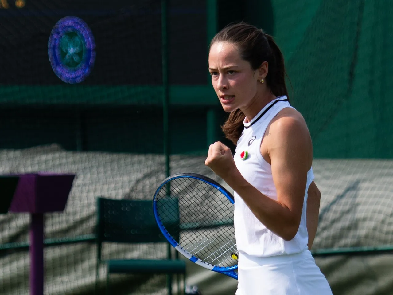 Zeynep Sönmez, 2024 Wimbledon elemelerinde çim kortta puan sonrası yumruğunu sıkarak sevinç yaşarken.