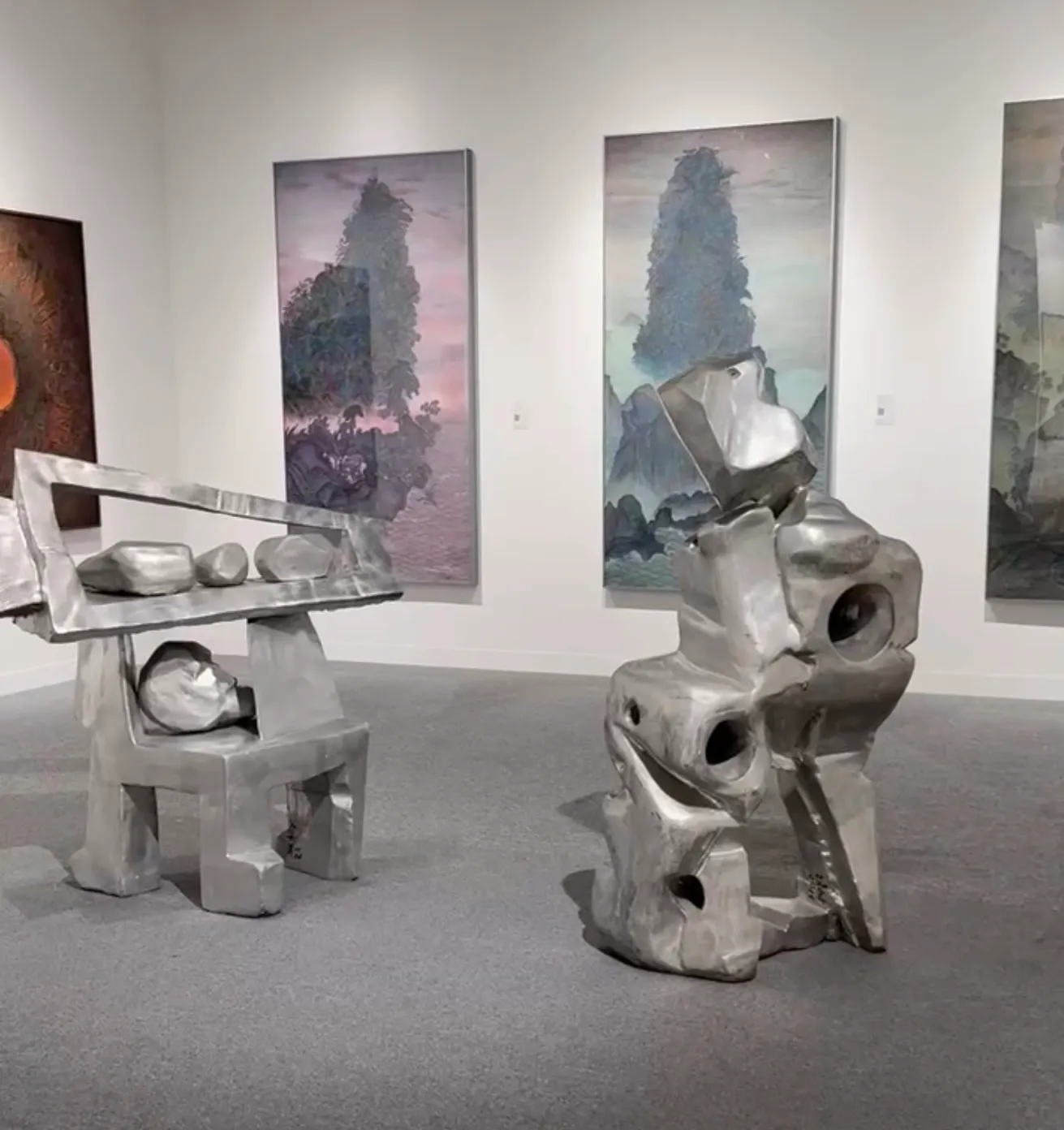 Abu Dhabi Art’ta çağdaş heykel yerleştirmeleri ve arka planda büyük ölçekli resimlerin yer aldığı sergi alanı