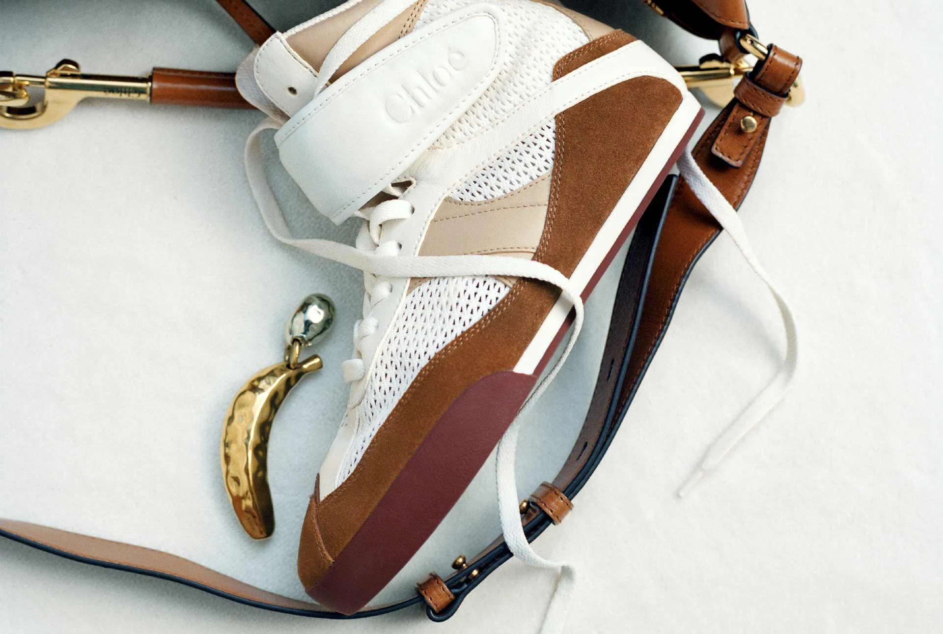 Chloé’nin karbon nötr ve sürdürülebilir moda yaklaşımını yansıtan sneaker tasarımı; doğal tonlar, geri dönüştürülmüş materyaller ve bilinçli lüks estetiği.