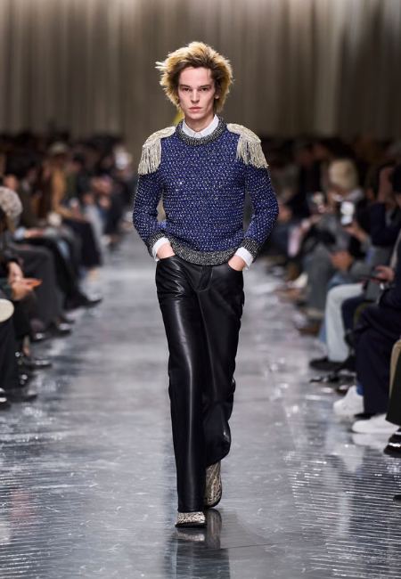 Dior 2026 sonbahar kış erkek koleksiyonu, püskül detaylı triko kazak ve siyah deri pantolon kombini.