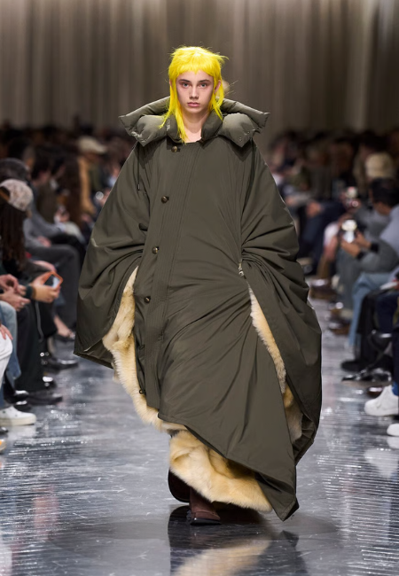 Dior 2026 sonbahar kış erkek defilesi, oversize haki puffer palto ve kürk detaylı podyum stili.