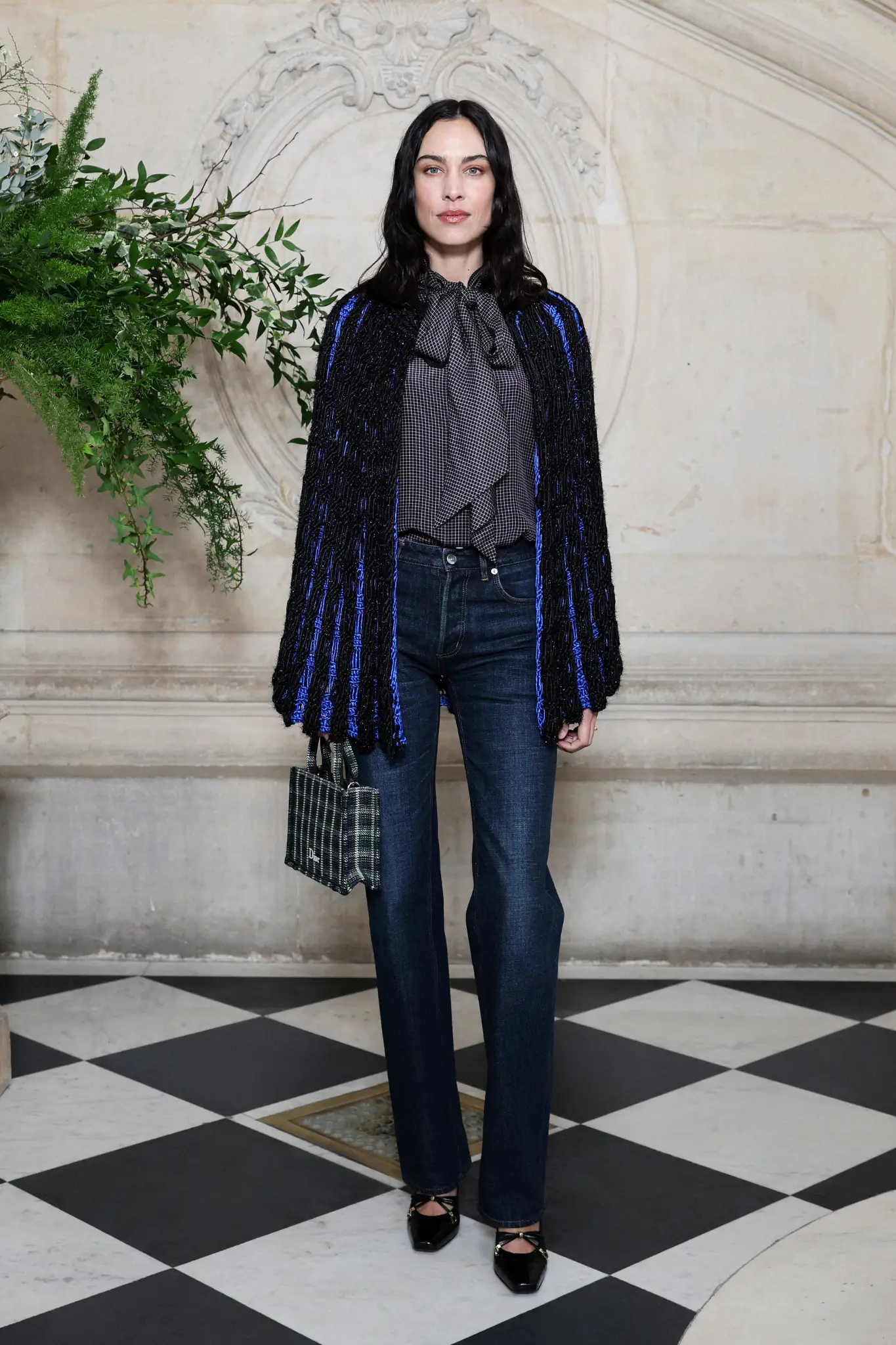 Alexa Chung Dior 2026 Couture defilesinde mavi detaylı ceket ve denim pantolon kombinasyonu.