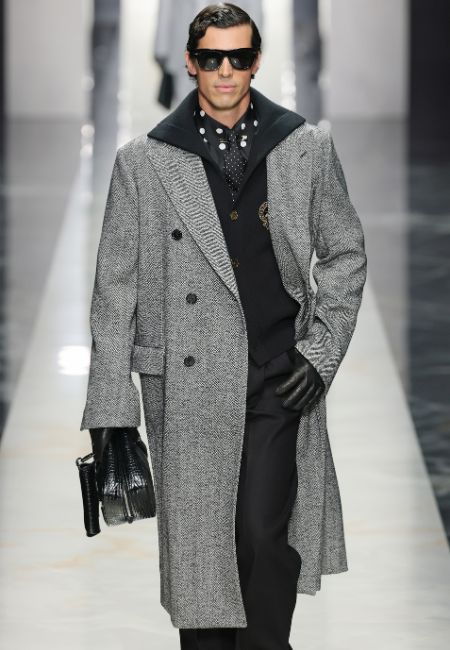 Dolce&Gabbana 2026 sonbahar kış erkek koleksiyonu gri balıksırtı palto, siyah katmanlı takım, güneş gözlüğü ve deri eldivenle runway stili.
