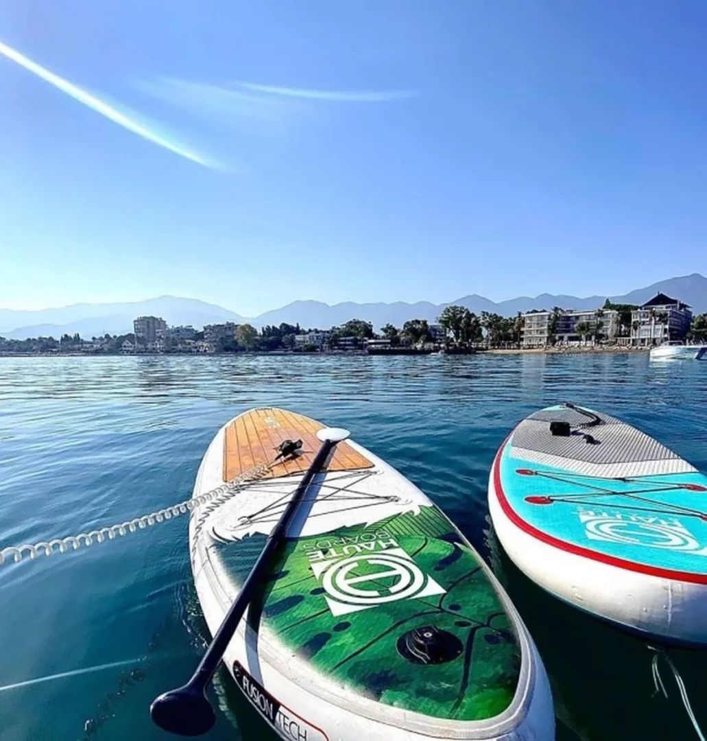 Datça, Türkiye’de sörf yapılacak yerler arasında SUP için öne çıkarken berrak mavi suda yan yana duran iki paddle board görülüyor.
