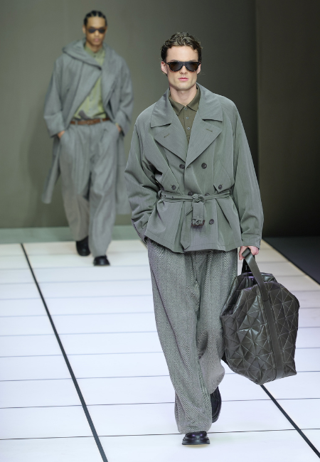 Giorgio Armani 2026 sonbahar kış gri kuşaklı ceket, desenli bol pantolon, güneş gözlüğü ve büyük çanta ile modern erkek giyim kombini.