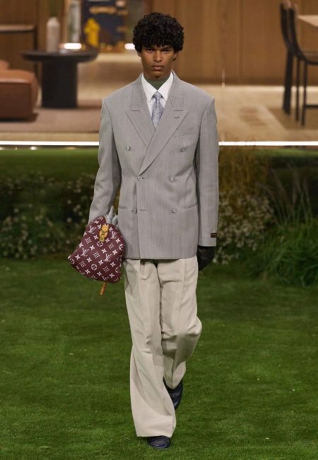 Louis Vuitton 2026 Sonbahar/Kış erkek defilesinde gri kruvaze blazer ve krem pantolon kombini, monogram çanta detayı.
