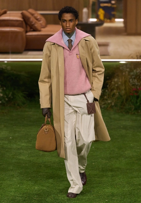 Louis Vuitton 2026 Sonbahar/Kış erkek podyumunda bej trençkot, pembe triko ve kahverengi çanta ile klasik stil.