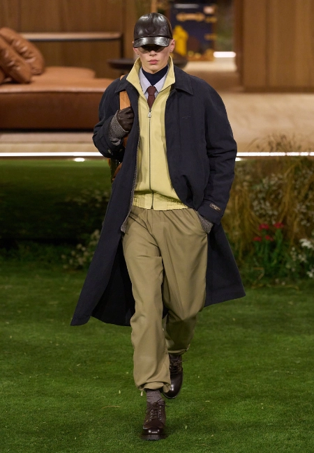Louis Vuitton 2026 Sonbahar/Kış erkek defilesinde deri şapkalı model, sarı triko ve uzun lacivert palto kombin