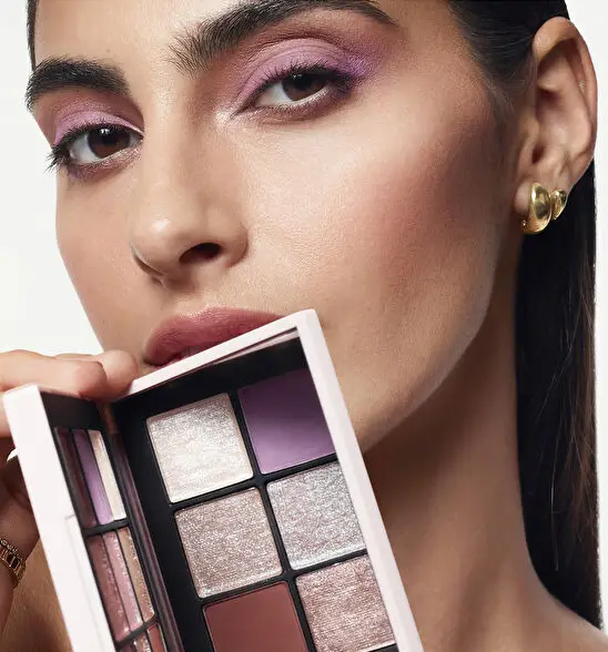 Nars Cosmetics Afterglow Tempting Far Paleti ile poz veren ışıltılı makyaj görünümüne sahip kadın