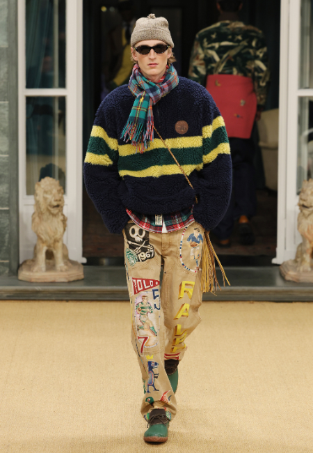 Ralph Lauren Milano 2026 erkek giyim lacivert-sarı çizgili peluş kazak, ekose atkı, bere ve desenli pantolon ile preppy stil.