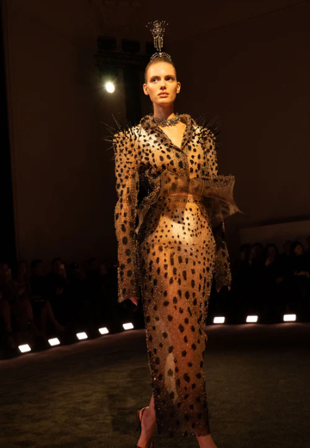 Schiaparelli 2026 couture koleksiyonu, leopar desenli transparan elbise ve heykelsi detaylarla podyum görünümü.