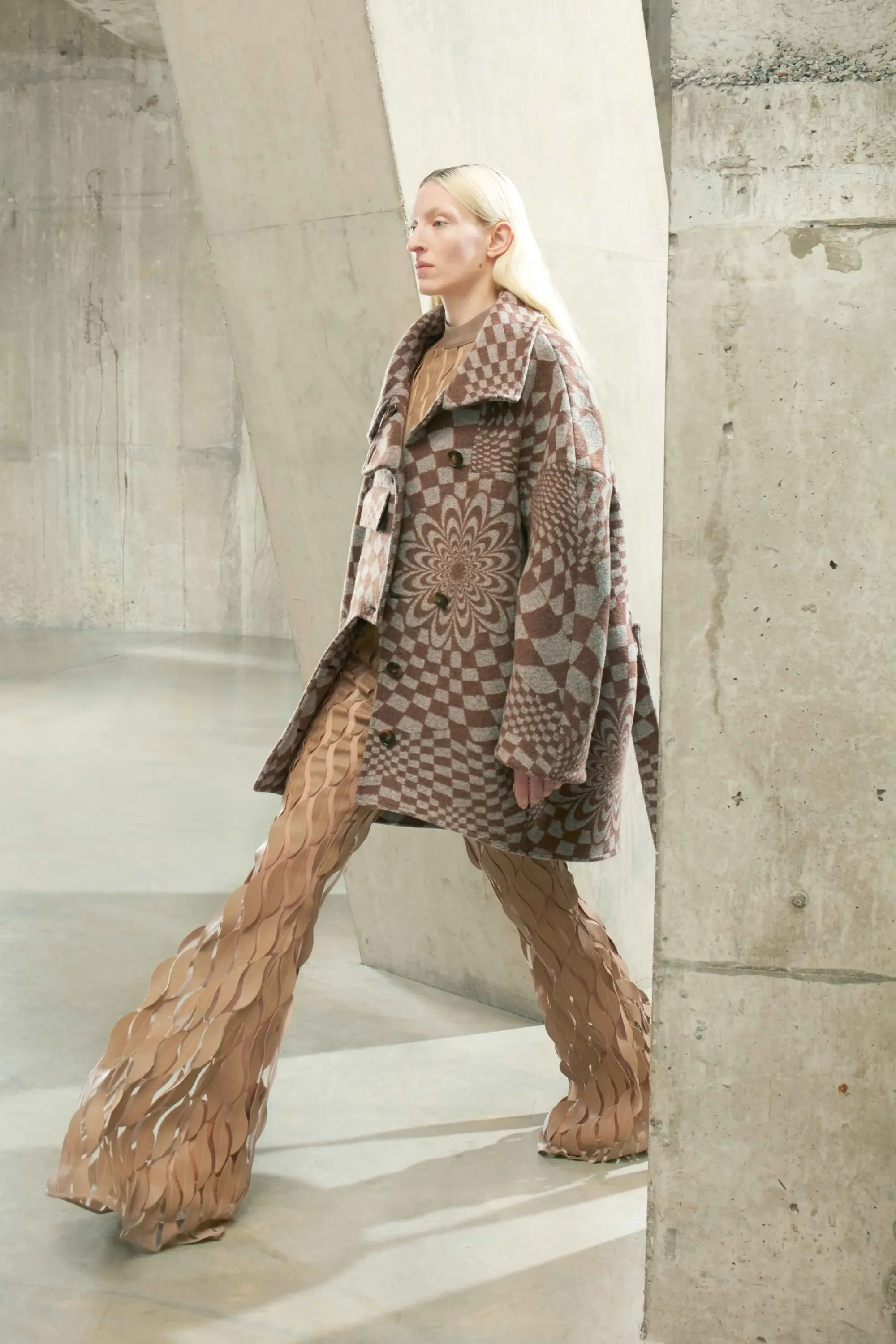 Stella McCartney Sonbahar/Kış 2021 koleksiyonunda geometrik desenli kaban ve heykelsi formda dokulu pantolonlarla deneysel silüet.