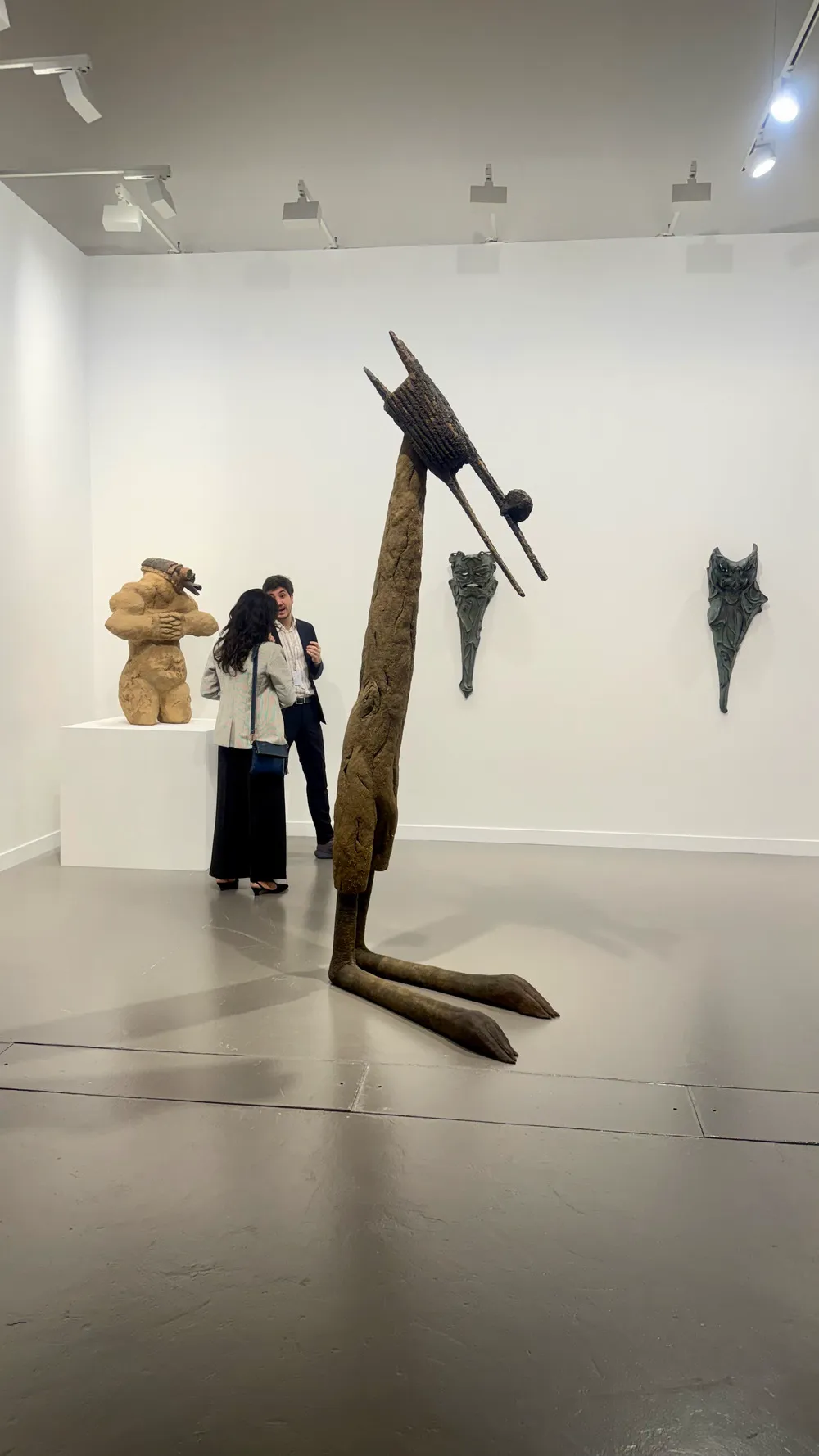 Art Basel Katar’da Ali Cherri’ye ait, uzun ve ince formuyla mekânda dikey bir etki yaratan heykel ve çevresinde sergilenen diğer çalışmalar.