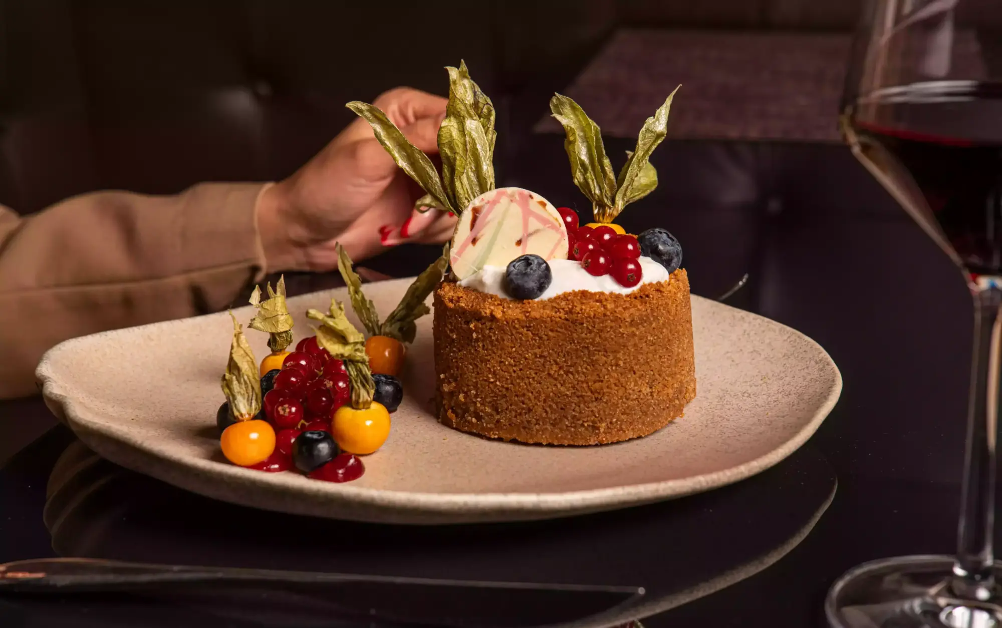 JW Steakhouse’ta meyveli özel tatlı sunumu ve kırmızı şarap eşliği