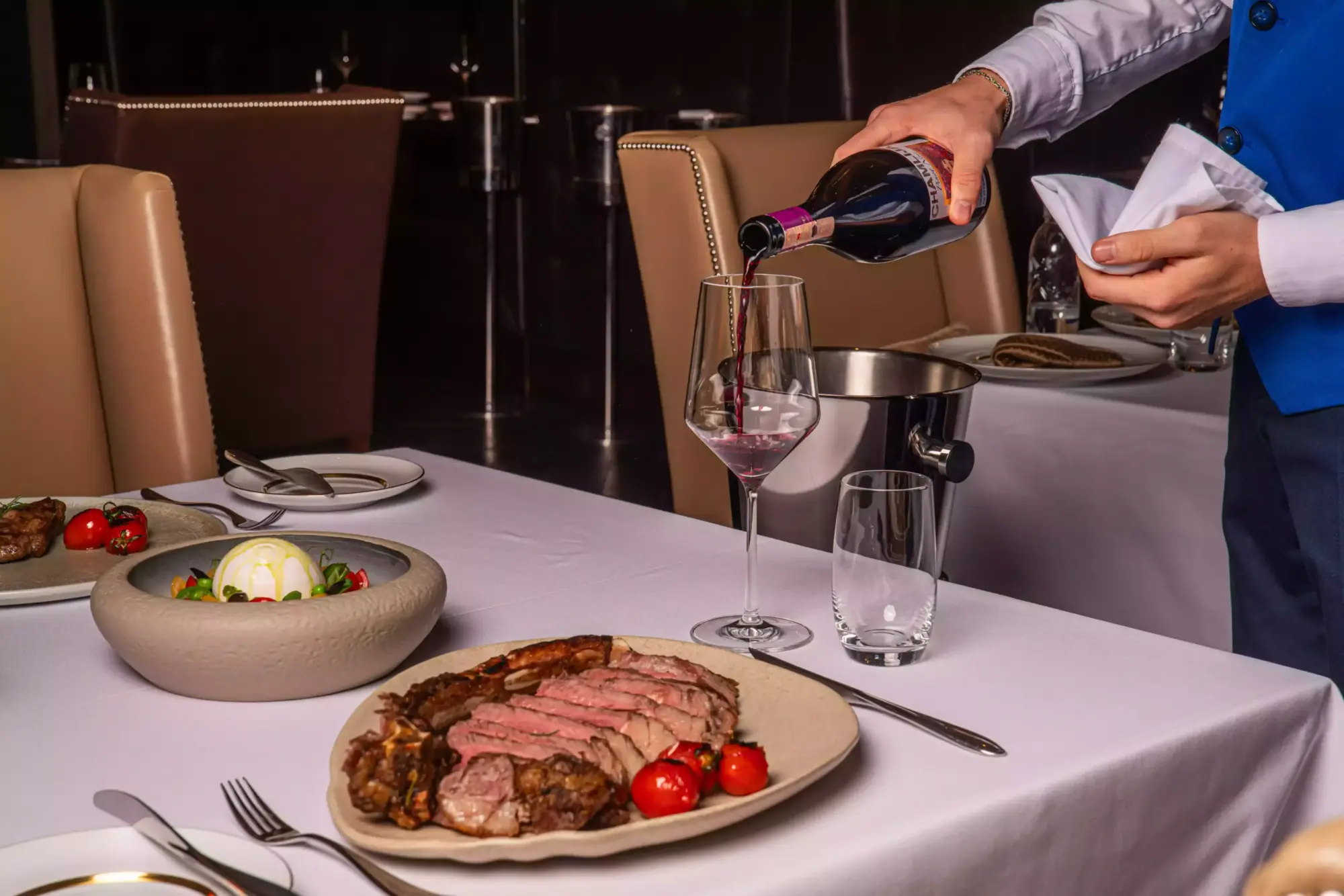 JW Steakhouse’ta dilimlenmiş tomahawk steak ve köz domates eşliğinde kırmızı şarap servisi, JW Marriott Hotel Ankara