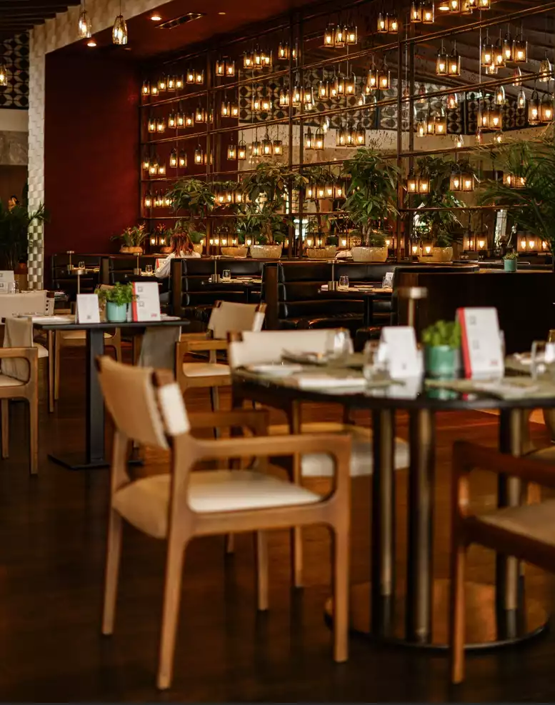 Oggusto - İstanbul’da Ramazan’a Özel Menüler: İftar İçin Nereye Gidilir? Ahşap sandalyeler, siyah deri localar ve yeşil bitkilerle tasarlanan şık restoran, aynalardan yansıyan sıcak sarkıt lambalarla aydınlanıyor. Hazır masalar, unutulmaz ve zarif iftar buluşmalarını temsil ediyor.