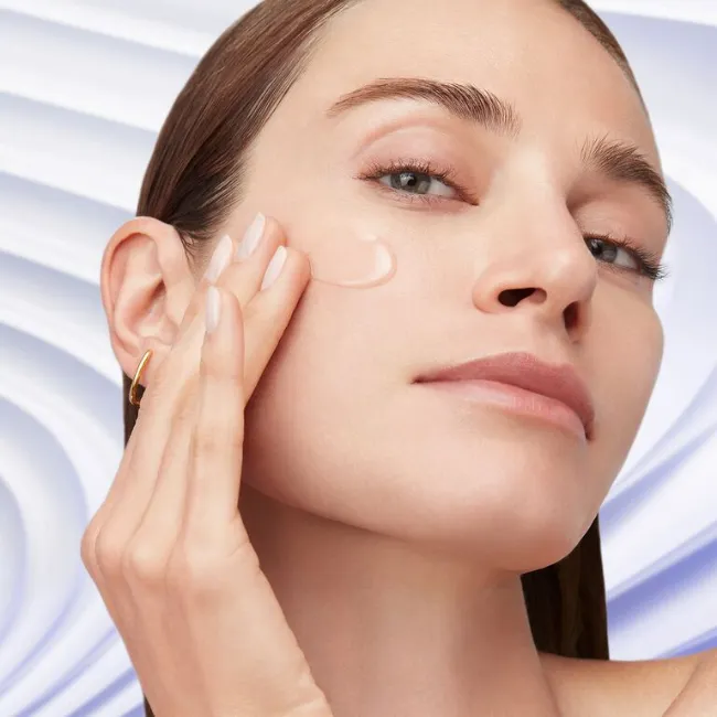 Lancome modeli, yüzüne nemlendirici ve aydınlatıcı serum uygulayarak cilt tonunu eşitleme ve parlaklık kazandırma adımını gösteriyor.