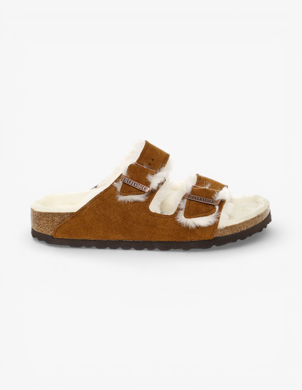 Marka Adı: Birkenstock
Ürün Cinsiyeti: Unisex
Ürün Tipi: Terlik
Ürün Sezonsallığı: Sonbahar/Kış
Ürün Çeşidi: İki bantlı süet terlik
Ürün Özellikleri: Bu Birkenstock terlik, kahverengi süet üst yüzeye ve iç kısımda krem rengi, yumuşak, kürklü bir astara sahiptir. Ürün, iki adet ayarlanabilir metal tokalı bantla tasarlanmıştır. Ayak anatomisine uyumlu mantar tabanı, uzun süreli konfor sağlarken, altındaki tırtıklı kauçuk dış taban kaymaz bir zemin tutuşu sunar. Açık burunlu ve kolay giyilebilir bu terlik, hem iç hem de dış mekan kullanımına uygun, sıcak ve stil sahibi bir tasarıma sahiptir.
Öne Çıkan Detaylar:
- Yumuşak, kürklü iç astar
- Ayarlanabilir, metal tokalı çift bant tasarımı
- Anatomik mantar taban yapısı
Kimler Kullanıyor?: Rahatlığı ve doğal materyalleri ön planda tutan, günlük şıklığına konfor katmayı seven herkes bu terliği tercih edebilir. Kış aylarında sıcaklık arayan, stilinde rahat ama modern bir dokunuş isteyen ve zamansız parçalarla gardırobunu zenginleştiren bireyler için idealdir. Ev içi kullanımda sıcak bir alternatif olmasının yanı sıra, dışarıda casual kombinleriyle de stilini tamamlamayı sevenler için uygun bir seçenektir.