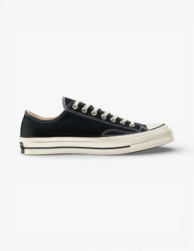 Marka Adı: Converse
Ürün Cinsiyeti: Unisex
Ürün Tipi: Sneaker
Ürün Sezonsallığı: Dört mevsim
Ürün Çeşidi: Chuck 70 Ox
Ürün Özellikleri: Siyah kanvas üst yüzeye sahip, bağcıklı ve bileksiz (low-top) bir spor ayakkabısıdır. Ayakkabının ana rengi siyahtır ve bu siyah yüzeyi belirgin beyaz dikişler çevreler. Krem veya kirli beyaz renkte kalın kauçuk bir tabanı ve aynı renkte yuvarlak bir burun koruyucusu (toe cap) bulunmaktadır. Tabanın yan kısmında, üst yüzey ile birleşim noktasında ince siyah bir şerit detayı yer alır. Krem renkli bağcıklar, metal halkalı deliklerden geçirilmiştir. Ayakkabının arka topuk kısmında, taban üzerinde küçük, siyah ve beyaz renkli bir marka logosu yaması mevcuttur.
Öne Çıkan Detaylar:
- Siyah kanvas üst yüzey ve kontrast oluşturan beyaz dikişler
- Kalın, kirli beyaz renkte kauçuk taban ve burun koruyucu
- Tabanda yer alan ince siyah şerit ve arka topuktaki marka logosu
Kimler Kullanıyor?: Klasik ve zamansız parçaları gardırobuna dahil etmeyi seven, günlük stilinde rahatlığı ve şıklığı bir arada arayan, ikonik tasarımları farklı kombinleriyle kişiselleştirmeyi tercih eden bireyler bu ayakkabıyı rahatlıkla kullanabilir. Denim pantolonlardan şortlara, elbiselerden eteklere kadar geniş bir yelpazede kombinlenebilen bu model, her yaş ve tarza hitap eden çok yönlü bir tamamlayıcıdır.
