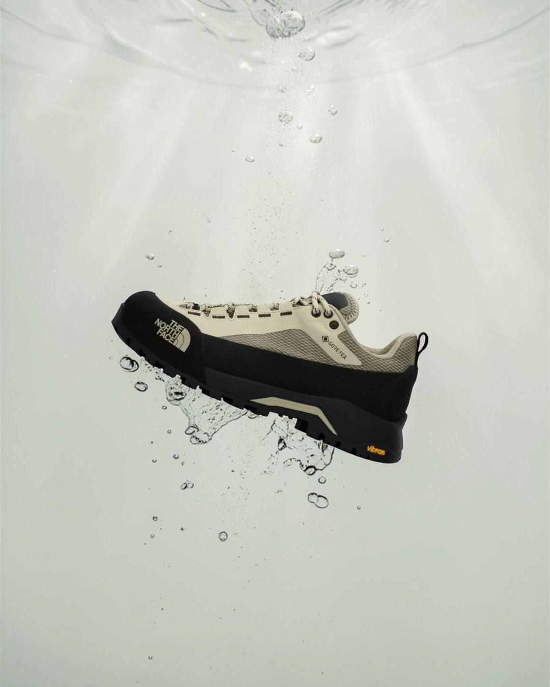Su sıçramaları içinde sergilenen GORE-TEX outdoor sneaker modeli, su geçirmez membran teknolojisi ve güçlü taban yapısıyla dört mevsim performans sunan teknik ayakkabı inovasyonunu temsil ediyor.