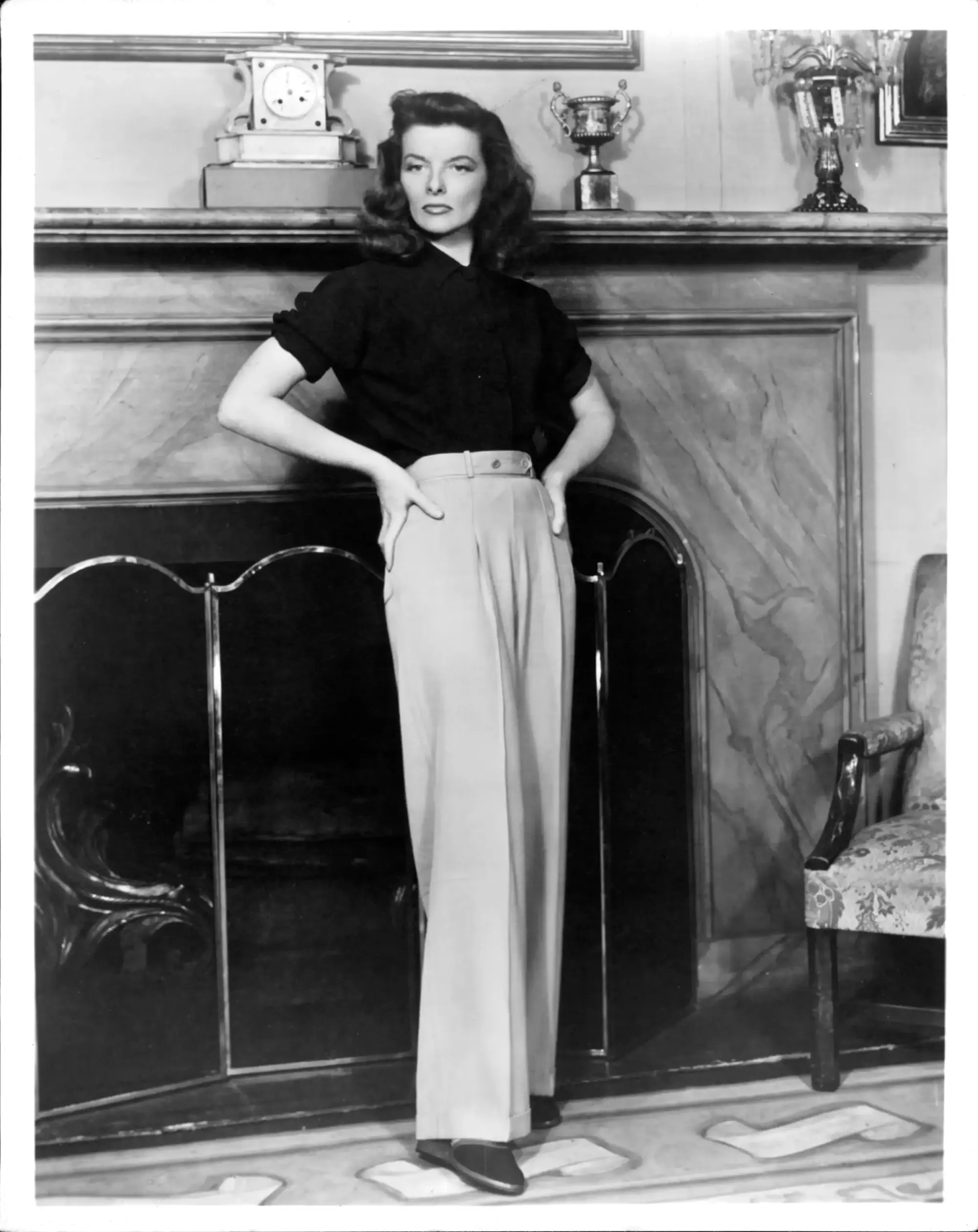 1940’lar stilini yansıtan wide leg pantolon giyen kadın; yüksek bel bol kesim pantolon ve gömlek kombinasyonu ile vintage moda ve zamansız kadın silueti.